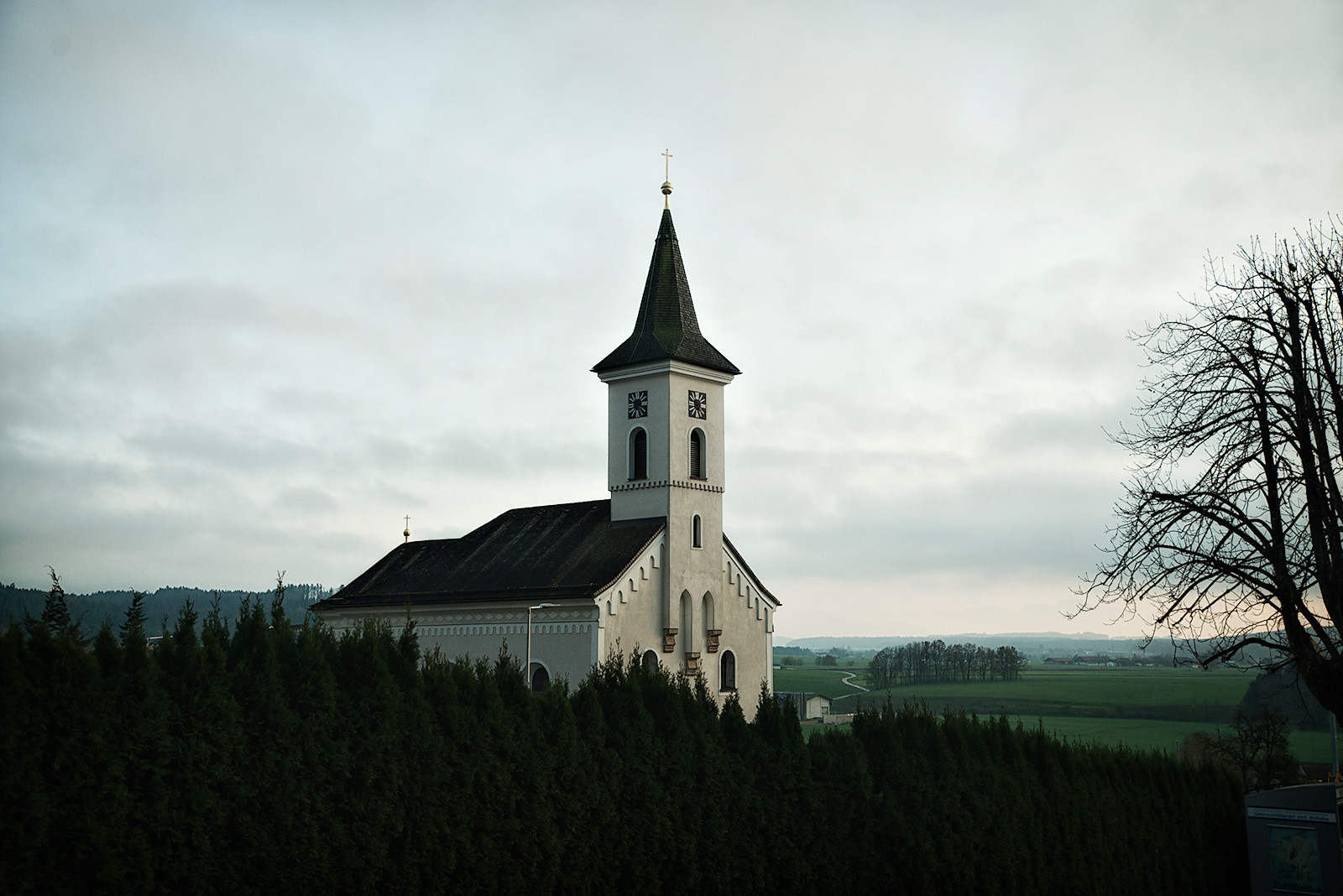 Blick auf Pfarrkirche Friedburg in der einsetzenden Dämmerung